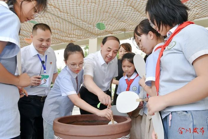　　▲华中师范大学国家教育治理研究院院长周洪宇教授（中）在合川区花果小学考察