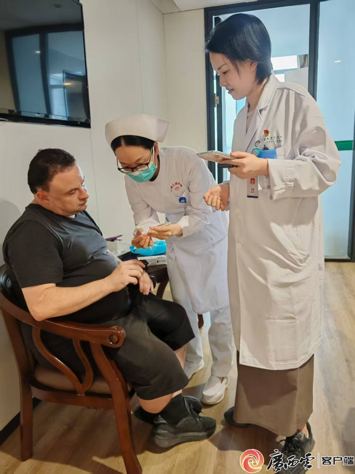 医生和护士正在指导外国患者用药。蒙晓宁 摄
