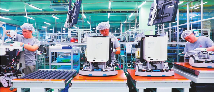        爱丽思中国集团工人们在流水线上精心组装智能商用清洁机器人。 金香 摄