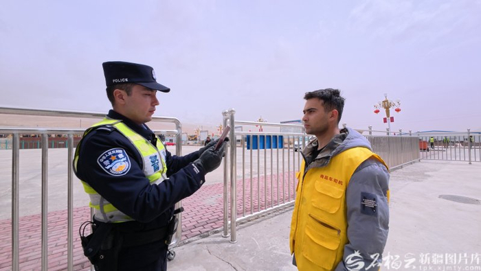 4月9日，卡拉苏边检站执勤民警在核对商品车司机的护照。雷俊华摄