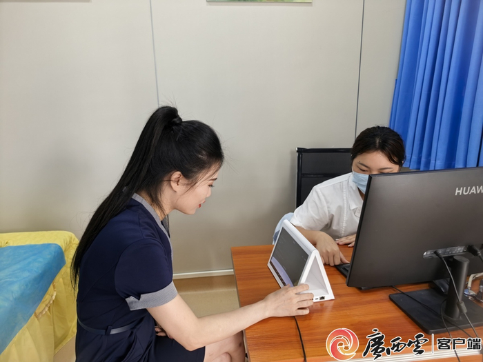 中越边民友好（水口）医疗服务站，越南患者与医生通过翻译器沟通。吕秀云 摄