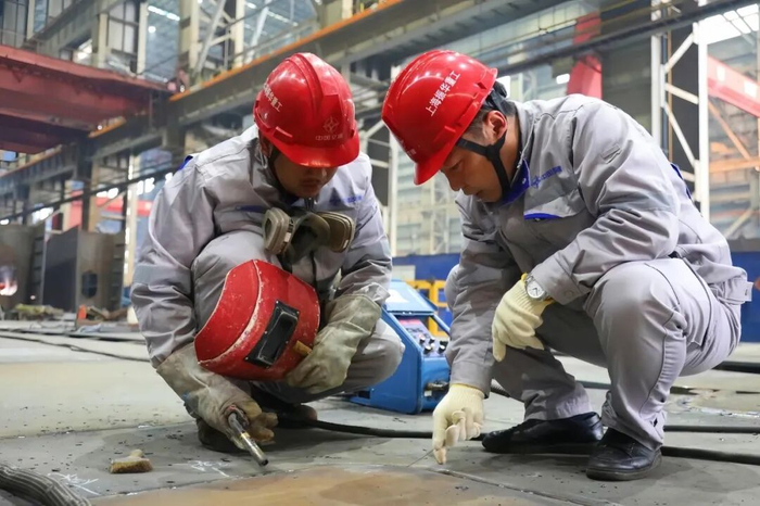 俸春林（左）和魏钧（右）在上海振华重工工作。 受访者供图