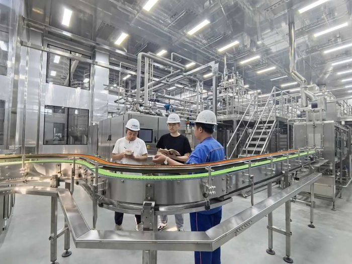 工人和技术人员正在核对智能无菌生产线的技术参数。王颖摄