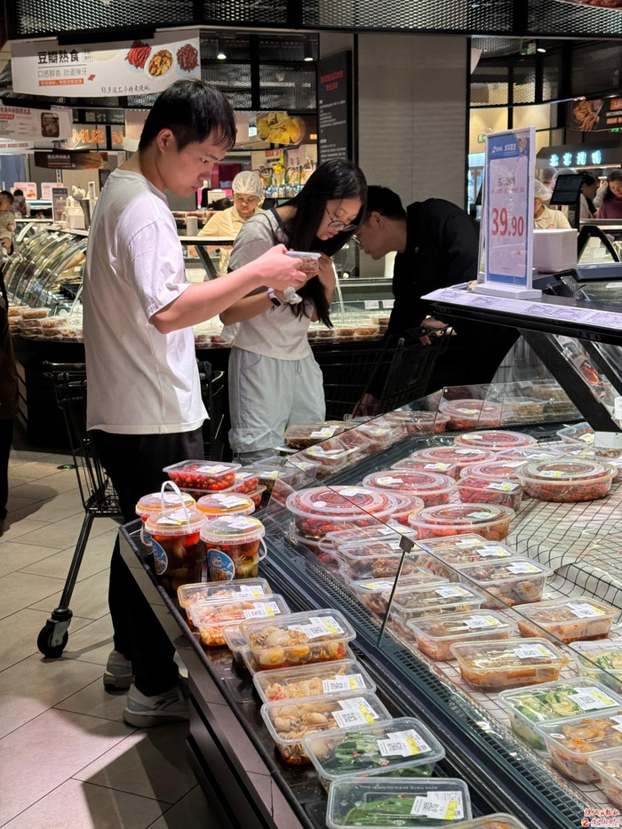 超市货架间，年轻人褪去随性，认真比价、精打细算。 记者/谢嘉 摄