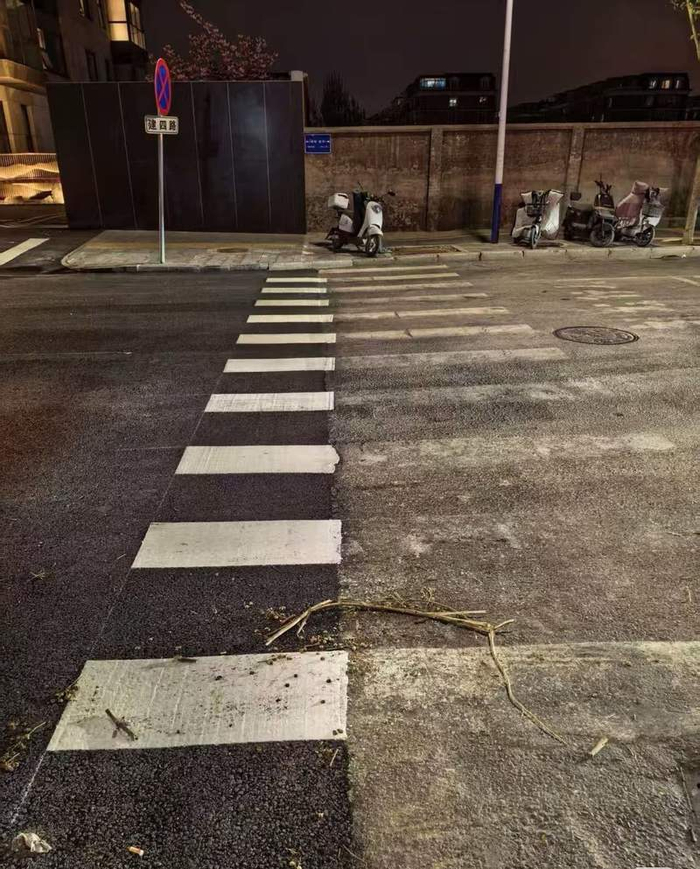 建四路位于昌平区与海淀区交界，图左侧为海淀区道路修整后，新划的斑马线只划到交界线处。居民供图