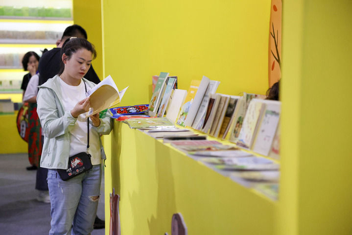 5月14日，观展者在第三届东北图书交易博览会现场阅读书籍。新华社记者 颜麟蕴摄