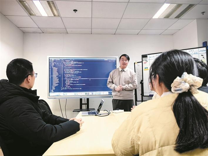     在上海理想信息产业（集团）有限公司，人工智能训练师（中）与团队人员协同工作（资料图片）。    新华社记者  周蕊  摄