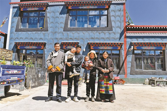 图为旺堆一家在新房前合影。记者　旦增嘎瓦　摄