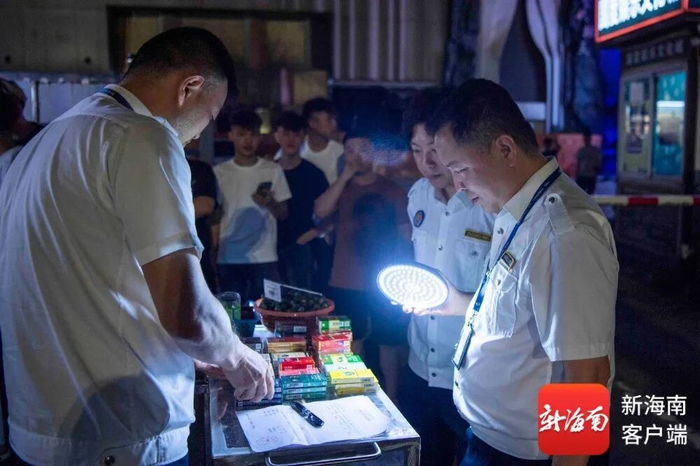 烟草稽查人员对销售涉假香烟的摊贩予以调查处理。记者 蒙健 摄