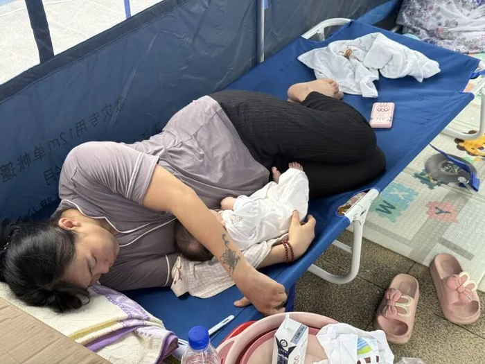 一名出生仅55天的女婴躺在母亲怀里