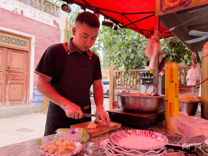 胡吉木&middot;吾吉阿布都拉正在为游客准备当地特色美食 （央广网记者 丁安 摄）
