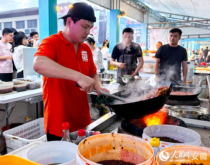 忙着颠锅烹饪小龙虾的龙少武。人民网记者 汪瑞华摄