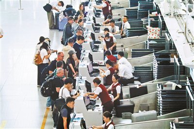 旅客在北京首都机场T3航站楼内办理乘机手续 供图/视觉中国