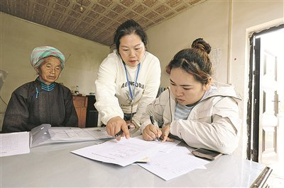 5月12日，陈泽琴（中）在贵安新区马场镇平寨村入户完善残疾人登记资料。     贵阳日报融媒体记者 石照昌 摄