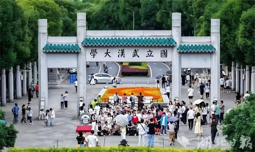 武大放开入校限制后首个双休日，校门口成了打卡点。图据湖北日报
