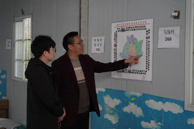 曾和春带着小曾深入研究物流图，摸排下乡配送路网。（胡弘彪|摄）