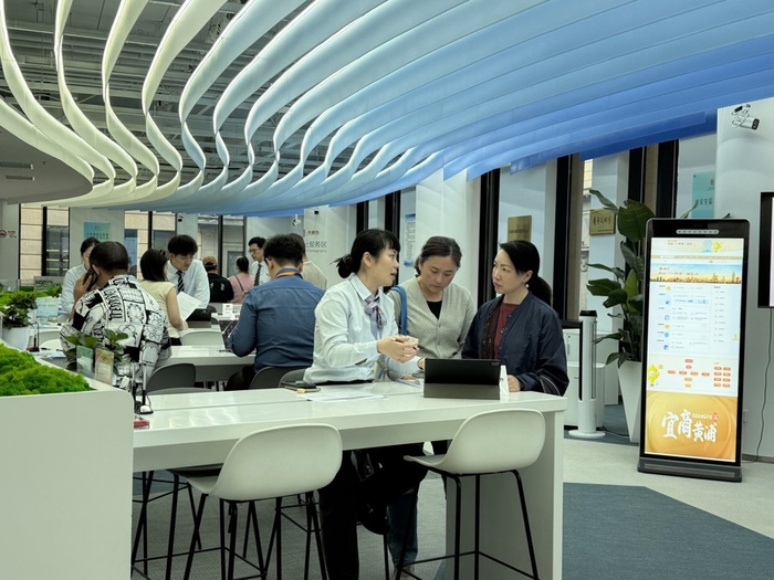 工作人员提供“肩并肩、面对面、手把手”的帮办服务，黄于悦摄