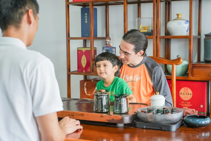 图为罗马尼亚青年创业者约瑟夫带着儿子，在公司与伙伴畅聊。图片来源：海南日报客户端