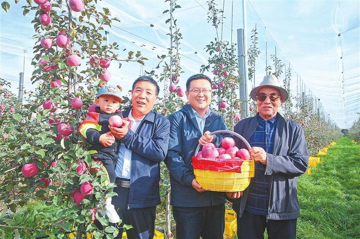 田积林（左二）四代人在果园里。本文图片由受访者提供