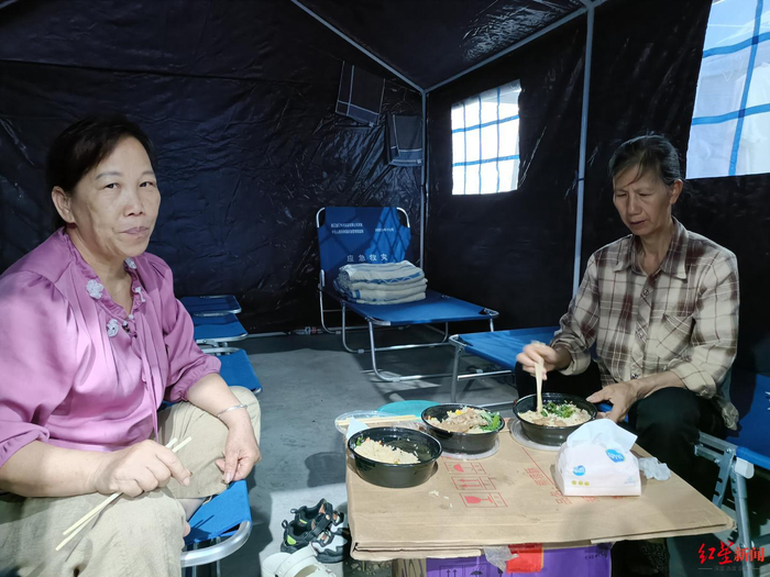 　▲周建香（左）和覃秀娥在河西工业园安置点的帐篷内&nbsp;