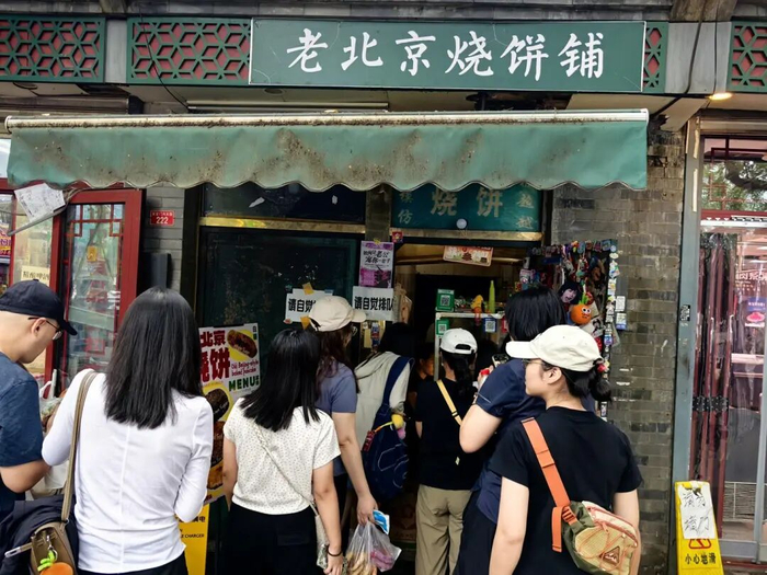 ▲2025年8月23日，北京，被五月天带火的这家老北京烧饼铺门口，许多年轻人正在排队买烧饼 图据IC photo