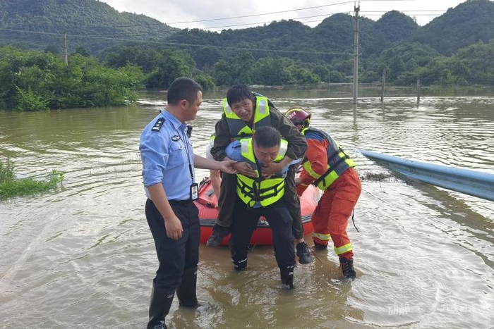 图为龙里县公安局民警救助被洪灾围困人员