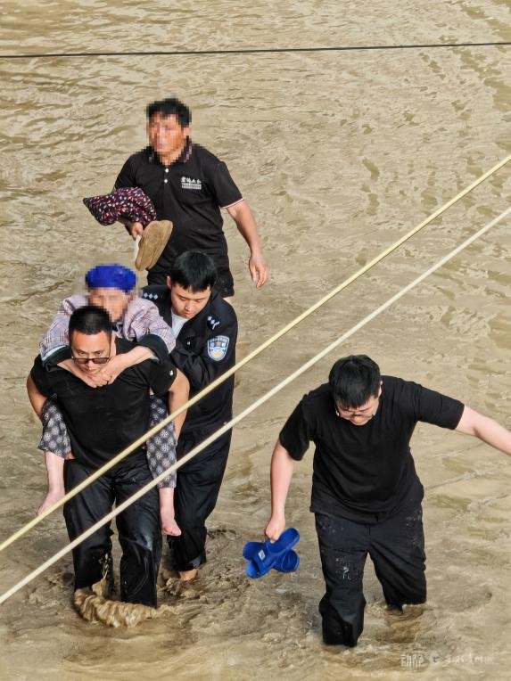 图为贵定县公安局民辅警救助被洪水围困人员