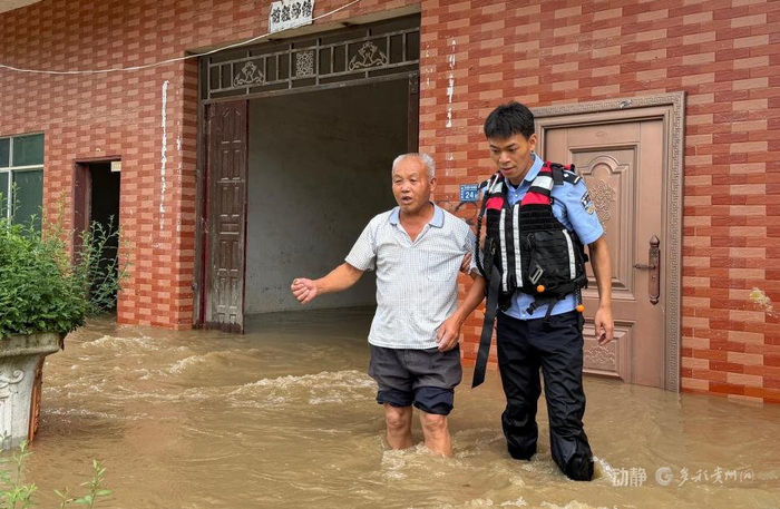 图为平塘县公安局金盆派出所民警潘国成转移受困群众