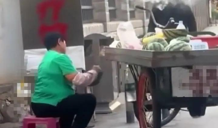 摊贩往西瓜切面涂抹不明液体。视频截图