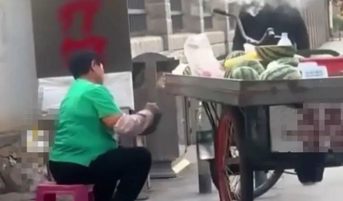 摊贩往西瓜切面涂抹不明液体。视频截图