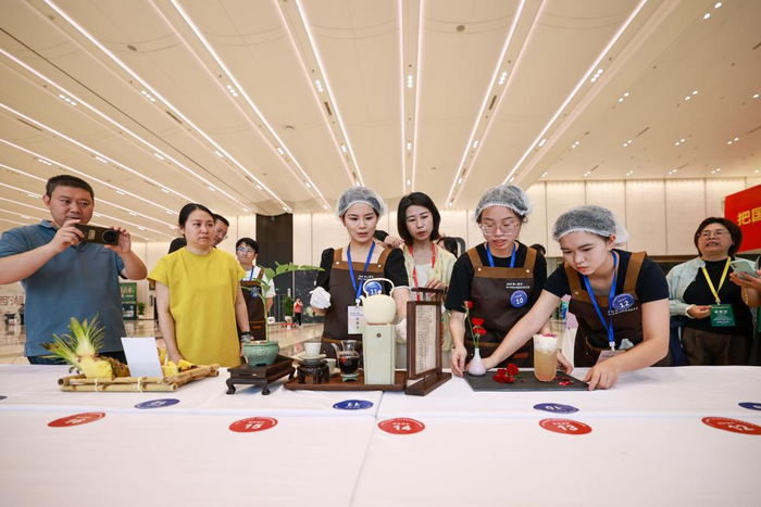 5月21日，观众在茶博会现场的浙江省新式调饮茶技能竞赛上欣赏参赛选手的作品。新华社记者 江汉 摄