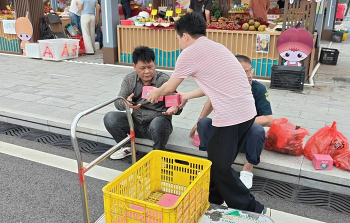 向过往游客发放荔枝礼盒