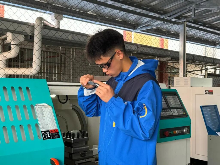 乐山市沐川县中等职业学校的车间里，身着“蓝鹰”服的学生正在上实操课。图源：新华社