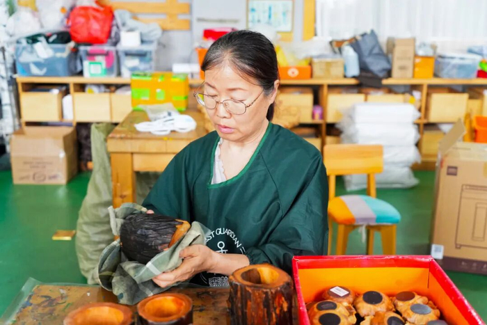 2026年5月12日，伊春永达工艺品有限公司员工正在擦拭制作好的松木工艺品。新华社记者 王祚 摄