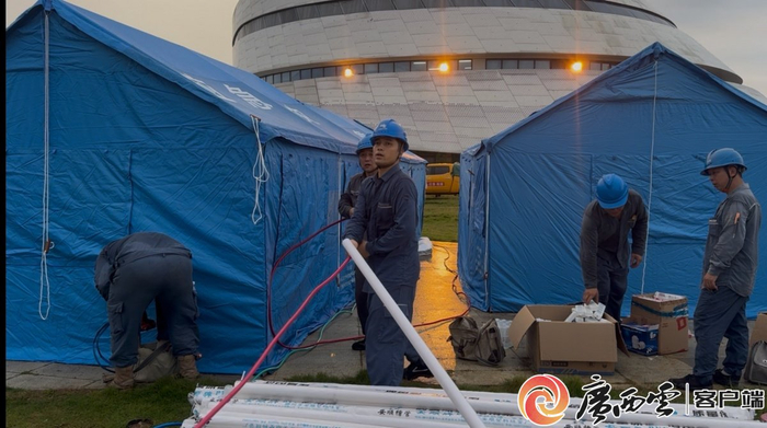 黄普杰（前）在螺蛳粉小镇集中安置点给应急帐篷拉线接电。广西云-广西日报通讯员 陆雯 摄