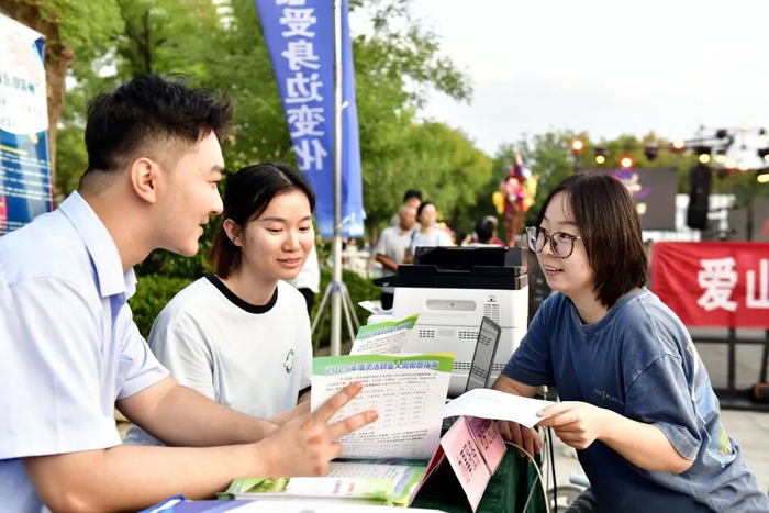 ▲资料图：山东省惠民县孙武广场，人社局工作人员向群众介绍相关服务。图/新华社