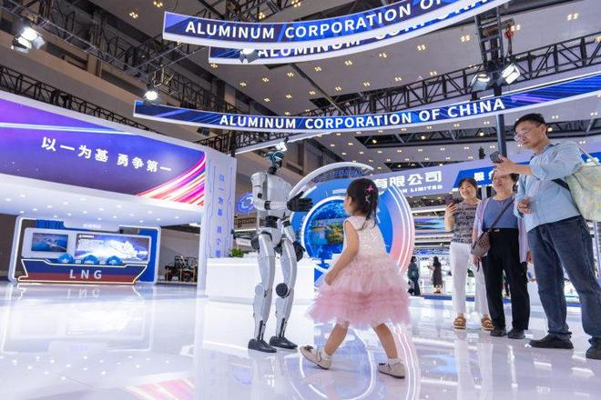 小朋友在中国铝业展馆与机器人互动。 主办方供图