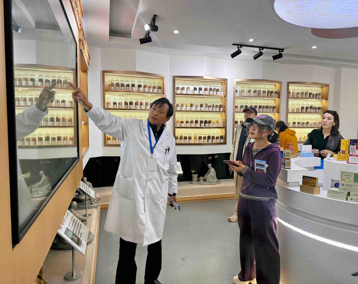 图为自治区食品药品检验研究院副主任药师次旦多吉向参观人员介绍中国藏药资源库。