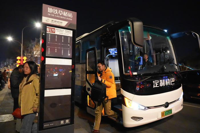 3月16日，在北京地铁草桥站附近，旅客走下一辆雄安新区至北京的定制快巴。
