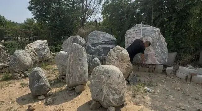 ▲5月13日，泰山附近一户“石农”正在测量一块泰山石的尺寸