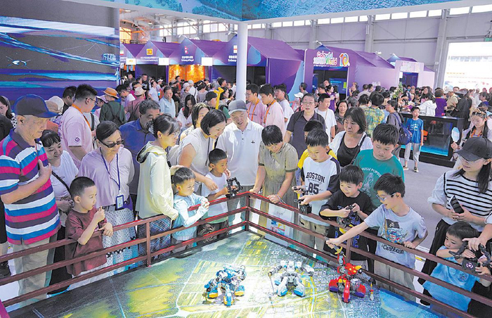 2025年9月14日，首钢园，服贸会文旅服务专题展，观众们围观格斗机器人。　资料图片/新京报记者　薛珺　摄