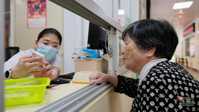 在市社会福利院，95岁的杨碧琳奶奶正在药师的引导下在药房前取药。吴玄摄