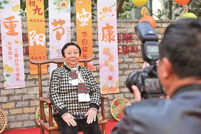 贵州贵阳晖福社区，志愿者在为老年人拍照。新华社发