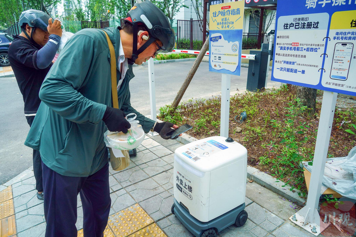 骑手将餐品放入机器人舱体 向宇 摄