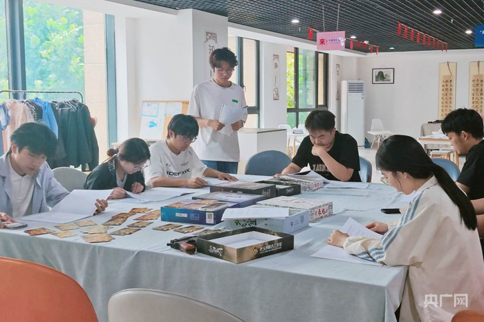 几名年轻人围坐桌旁，进行网络安全主题剧本杀（央广网记者  张羲轮  摄）