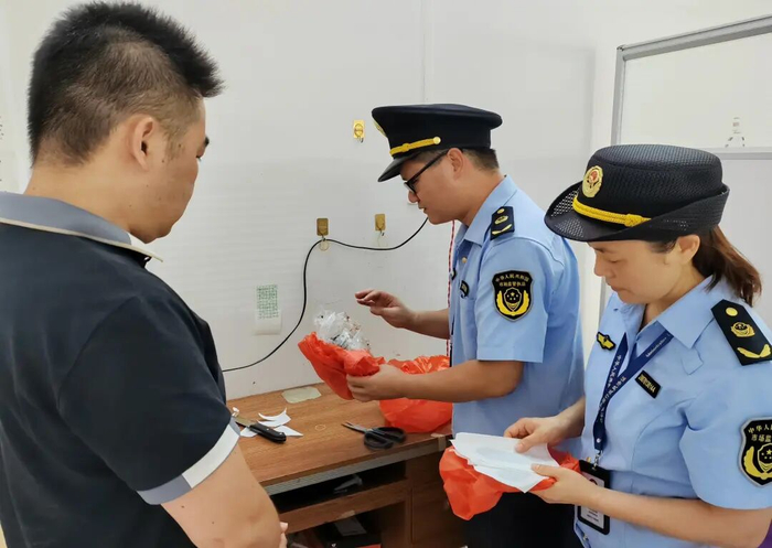 执法人员检查经营者自制的膏药及其原料。灵山县市场监管局供图