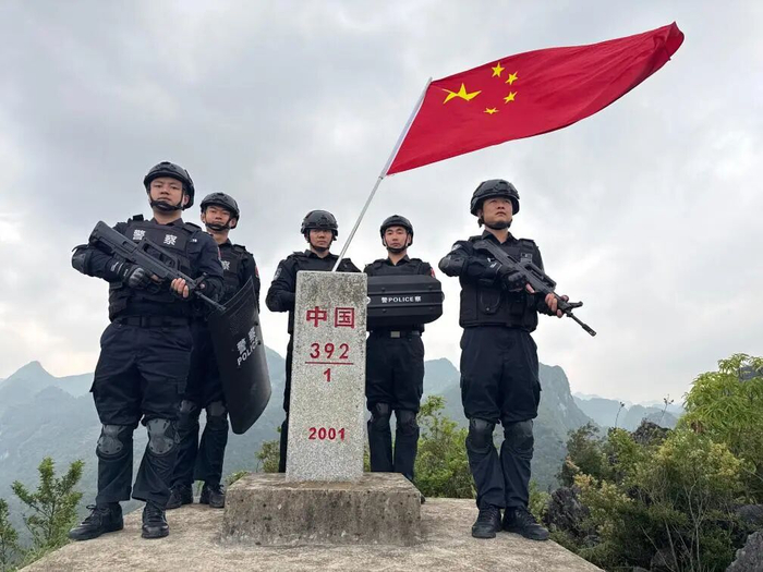 范慧康与战友在边境巡逻时与界碑合影。新华社发