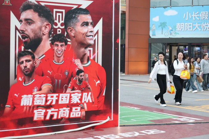 △市民经过北京一家世界杯豪门IP授权店。（资料图，图片由CNSPHOTO提供）