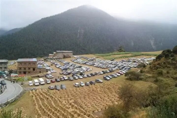 2013年前，开进稻城亚丁景区的私家车停靠在亚丁村旁（资料照片）。新华社发