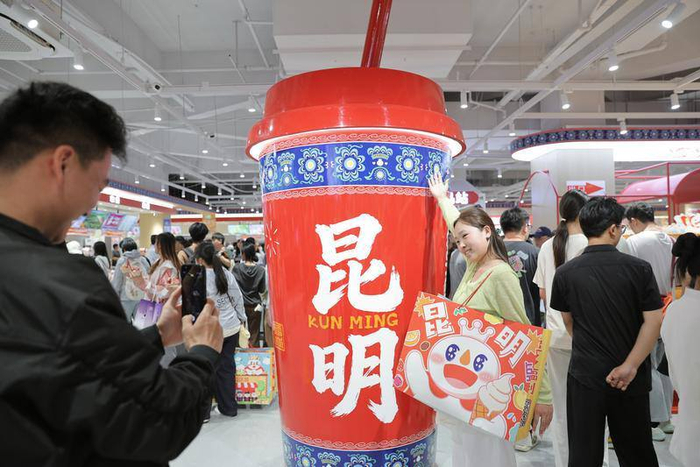 人们在蜜雪冰城昆明旗舰店内打卡拍照。